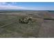 Expansive aerial view of property featuring a farmhouse, outbuildings, and vast open land under a blue sky with sparse clouds at 7409 S County Road 157, Strasburg, CO 80136