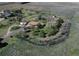 Expansive aerial view of a charming ranch home surrounded by mature trees and lush landscaping in a serene setting at 7409 S County Road 157, Strasburg, CO 80136