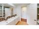 Bathroom with double vanity, large mirror, and storage shelves for a practical and organized space at 7409 S County Road 157, Strasburg, CO 80136