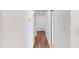 Neutral hallway with wood floors and white walls at 7409 S County Road 157, Strasburg, CO 80136