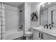 Updated bathroom features a shower-tub combo, modern vanity, and stylish black and white decor at 7132 Eagle Rock Dr, Littleton, CO 80125