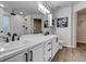Stylish bathroom featuring dual sinks, white cabinets, and a walk-in shower at 7132 Eagle Rock Dr, Littleton, CO 80125