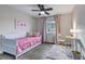 Comfortable bedroom with pink bedding, a ceiling fan, and a bright workspace at 7132 Eagle Rock Dr, Littleton, CO 80125