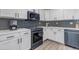 Well-equipped kitchen with modern appliances, white cabinets, mosaic backsplash, and ample counter space at 7132 Eagle Rock Dr, Littleton, CO 80125