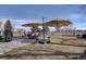Spacious backyard with a patio, outdoor seating under large umbrellas, and mature trees at 7160 S Jellison St, Littleton, CO 80128