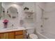 All-white bathroom featuring tiled shower and tub, shelves, and modern mirror at 7160 S Jellison St, Littleton, CO 80128