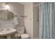Bathroom featuring a pedestal sink, toilet, glass shelving, and shower with a blue floral curtain at 7160 S Jellison St, Littleton, CO 80128