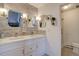 Bright bathroom features dual sinks, wood accent wall, and tiled floors at 7160 S Jellison St, Littleton, CO 80128