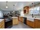 Featuring a farmhouse sink, wood cabinets and an island, this kitchen seamlessly connects to a cozy living space at 7160 S Jellison St, Littleton, CO 80128