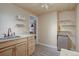 Cozy kitchen with light wood cabinets, floating shelves, stainless steel refrigerator, and tile backsplash at 7160 S Jellison St, Littleton, CO 80128