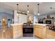 This open-concept kitchen features modern appliances and lighting, blending style and functionality for culinary enthusiasts at 7160 S Jellison St, Littleton, CO 80128