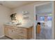 Small kitchenette features wood cabinets, tile backsplash, shelves and utility sink at 7160 S Jellison St, Littleton, CO 80128