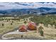 A high-angle aerial view of a log home and garage surrounded by nature, near treed mountains at 401 Raptor Point Rd, Golden, CO 80403