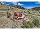 An aerial view reveals a log home on a lush hillside offering privacy and stunning vistas at 401 Raptor Point Rd, Golden, CO 80403