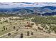 An expansive aerial view reveals a secluded log home nestled amidst rolling hills and lush forests at 401 Raptor Point Rd, Golden, CO 80403