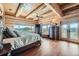 Log cabin main bedroom with hardwood floors, expansive windows and scenic views at 401 Raptor Point Rd, Golden, CO 80403