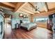 Cozy main bedroom featuring hardwood floors, log beam ceiling, and picturesque views at 401 Raptor Point Rd, Golden, CO 80403