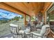 Relaxing outdoor seating area on a covered deck, offering stunning views of the surrounding landscape at 401 Raptor Point Rd, Golden, CO 80403