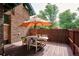 Outdoor dining on the wood deck features a wooden table and seating beneath a patio umbrella at 2201 Cherry St, Denver, CO 80207