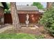 Backyard landscape featuring a statue, flower bed, privacy fence and trees at 2201 Cherry St, Denver, CO 80207