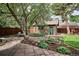Brick outbuilding with a green door and a patio with stone pavers and mature trees at 2201 Cherry St, Denver, CO 80207