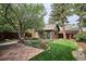 Brick outbuilding with a green door and a patio with stone pavers and landscaping at 2201 Cherry St, Denver, CO 80207