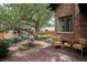 Private backyard oasis with mature trees, wood deck, and stone patio seating at 2201 Cherry St, Denver, CO 80207