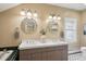 Well-lit bathroom with double sinks, decorative mirrors, and modern lighting fixtures at 2201 Cherry St, Denver, CO 80207