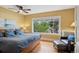 Sunny bedroom with hardwood floors, a large window with view of the trees, and a sitting area at 2201 Cherry St, Denver, CO 80207