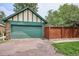 Two car garage with green door and brick driveway at 2201 Cherry St, Denver, CO 80207
