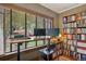 Bright office space with large window, custom shelving filled with books, and a two-monitor desk setup at 2201 Cherry St, Denver, CO 80207