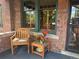 Inviting porch with a cozy seating area, including a chair and a table with decorative flowers and oranges at 2201 Cherry St, Denver, CO 80207
