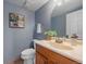 Bathroom featuring blue walls, single sink vanity, decorative art, and a mirror at 18263 E Mansfield Ave, Aurora, CO 80013