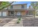 Inviting two-story home with a charming brick facade, tidy landscaping, and an American flag at 18263 E Mansfield Ave, Aurora, CO 80013