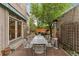 Backyard patio with outdoor seating, heater, lush greenery, and a shade tree at 635 N Williams St, Denver, CO 80218