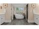 Bright bathroom features white cabinets, wood look tile floors, a soaking tub, and a glass enclosed shower at 635 N Williams St, Denver, CO 80218