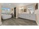 Modern bathroom featuring wood look tile flooring, a soaking tub, large windows, and a walk in shower at 635 N Williams St, Denver, CO 80218