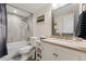 Bright bathroom featuring a shower-tub, tile surround, and a vanity with framed mirror at 635 N Williams St, Denver, CO 80218