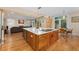 Open kitchen design with an island cooktop, hardwood floors, and seamless flow into the living area at 635 N Williams St, Denver, CO 80218