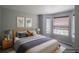 Staged bedroom with a large bed, stylish decor, and a bay window, creating a relaxing atmosphere at 12208 W Dorado Pl # 207, Littleton, CO 80127