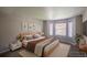 Stylishly staged bedroom with a plush bed, bay windows, and side tables for a cozy feel at 12208 W Dorado Pl # 207, Littleton, CO 80127