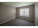 Neutral bedroom featuring gray carpet, neutral walls, and a large window with wooded views at 12208 W Dorado Pl # 207, Littleton, CO 80127
