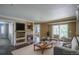 Staged living room highlighting the fireplace, balcony, and hardwood floors at 12208 W Dorado Pl # 207, Littleton, CO 80127