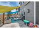 Back patio shaded by a colorful awning with outdoor seating, grill, and play area at 6792 Canosa St, Denver, CO 80221