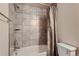 Full bathroom featuring a shower and tub with tiled walls and a standard white toilet at 6792 Canosa St, Denver, CO 80221