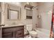 Cozy bathroom featuring shower-tub combo, stylish vanity, and decorative mirror at 6792 Canosa St, Denver, CO 80221