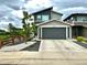 View of the home's front exterior showcasing a modern design, large garage door, and well-kept landscaping at 6792 Canosa St, Denver, CO 80221
