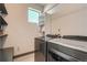Bright laundry room featuring a modern washer and dryer set, shelving, and a window for natural light at 6792 Canosa St, Denver, CO 80221