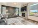 Living room with a large gray sectional couch, fireplace with modern tile surround, and natural light at 6792 Canosa St, Denver, CO 80221