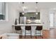 Modern kitchen featuring a breakfast bar with seating and stainless steel appliances adjacent to living room area at 1236 N Tennyson St, Denver, CO 80204